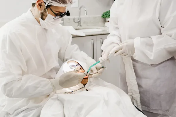 Two dentists treating a patient in a clinic
